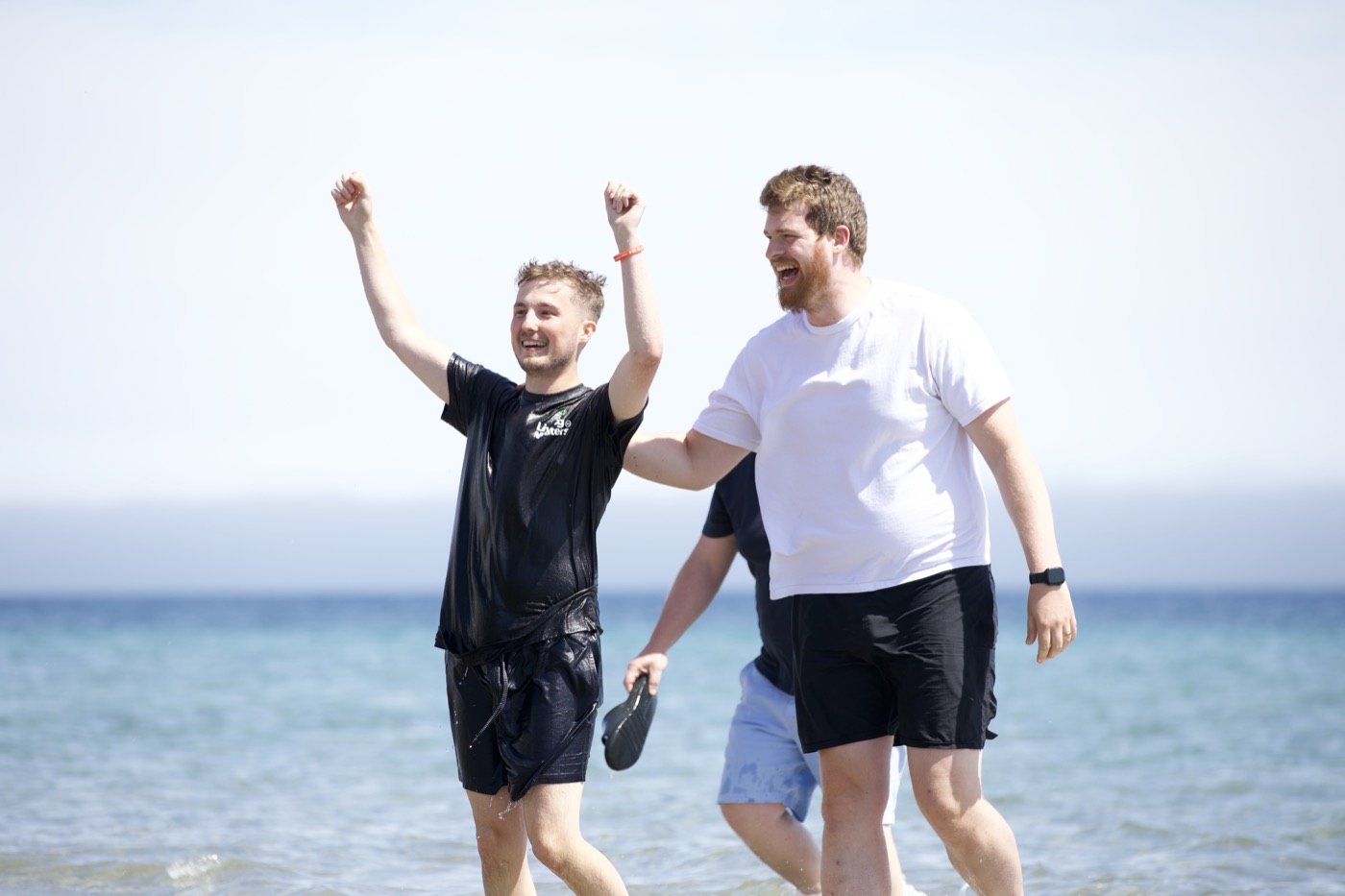 Two people celebrating after a baptism in the sea
