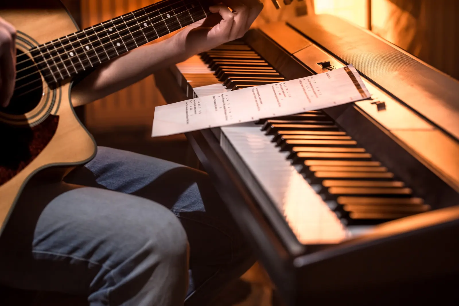 Guitar and keyboard beside a printed chord sheet